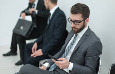 Grup ofis alma içinde oturan bir toplantı için bekleyen iş adamları.