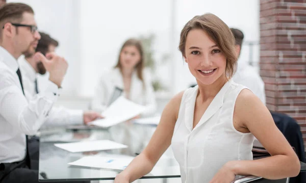 Femme d'affaires souriante assise devant le bureau — Photo