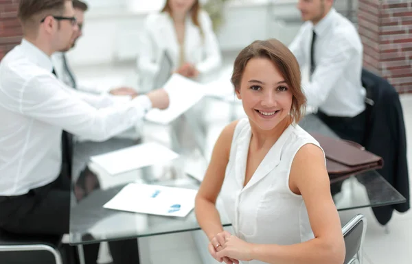 Uśmiechnięta kobieta biznesu siedzi przed biurkiem — Zdjęcie stockowe