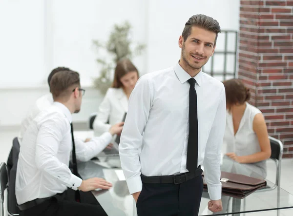 Succesvolle jonge zakenman die permanent in het kantoor — Stockfoto