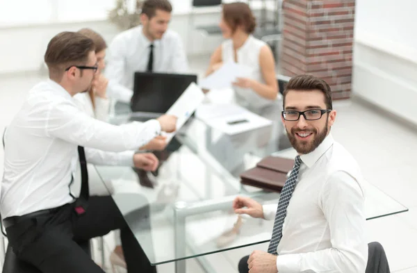 Gerente sentado en su escritorio y mirando a la cámara — Foto de Stock