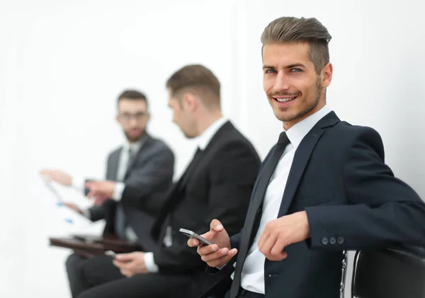 Jovem empresário sentado na recepção do escritório — Fotografia de Stock