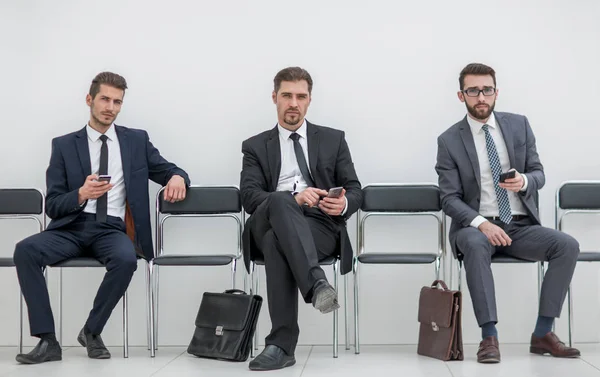 Gruppe von Geschäftsleuten mit Smartphones im Büroflur — Stockfoto