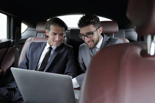Два бізнесмена розмовляють, сидячи в машині — стокове фото