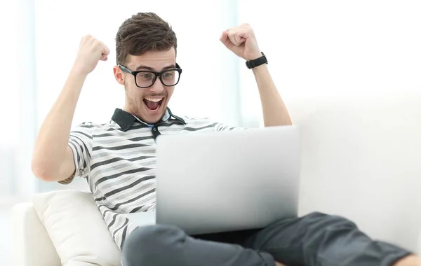 Homem feliz com laptop sentado no sofá — Fotografia de Stock