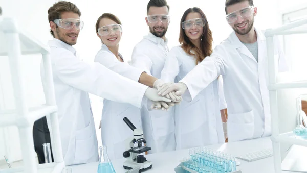 Επιτυχημένη ομάδα νέων επιστημόνων με τα χέρια ενωμένα μαζί. — Φωτογραφία Αρχείου