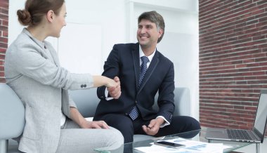 İş adamları iş yerinde otururken el sıkışıyor