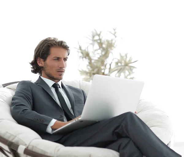 大規模な快適な armchai に座っているラップトップで成功した実業家 — ストック写真