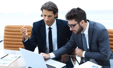 dizüstü bilgisayarda çalışan iki iş adamı