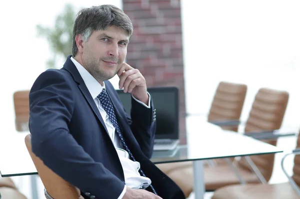 Pensive businessman sitting at office desk in office — Stock Photo, Image