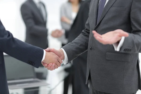 Business partners handshaking over business objects on workplace — Stock Photo, Image