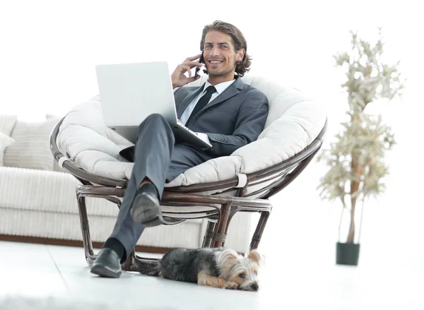 Homme d'affaires parlant sur un smartphone assis dans le salon — Photo