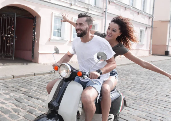 mutlu genç bir çift bir scooter üzerinde eğleniyor