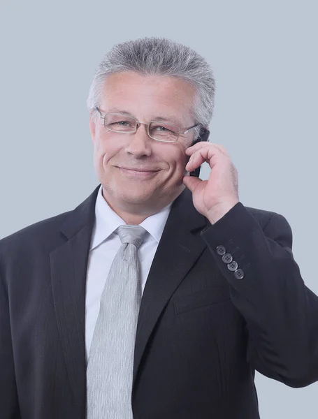 Portrait of smiling senior businessman standing against gray — Stock Photo, Image