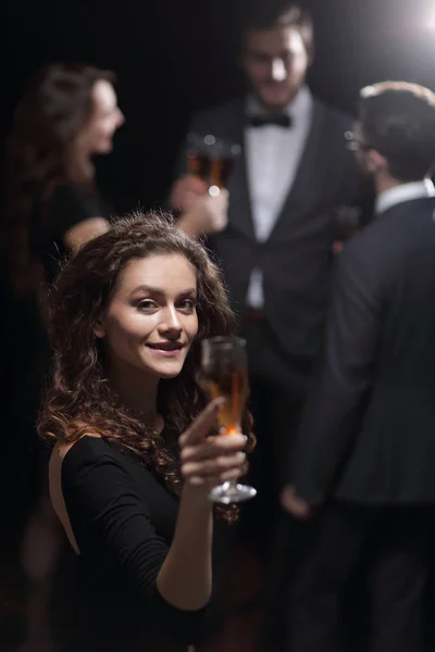 シャンパンのグラスを上げるスタイリッシュな若い女性 — ストック写真