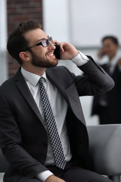 Чарівний бізнесмен розмовляє по телефону в сучасній будівлі — стокове фото