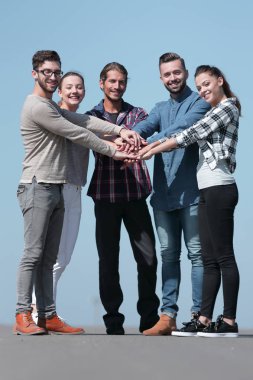 bir grup genç insan birlikte ellerini sıktı