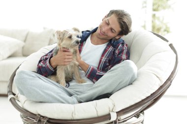 yakışıklı olan büyük bir koltukta oturan bir köpekle.