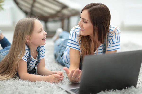 Mãe e pequena filha discutindo algo enquanto olha para o laptop — Fotografia de Stock