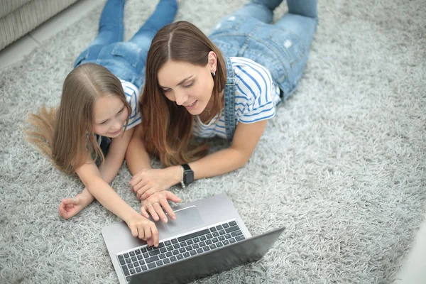 Närbild. Mamma och hennes lilla dotter spelar på laptopen — Stockfoto