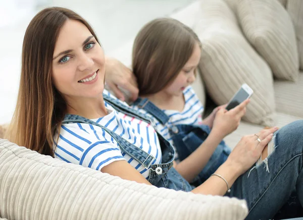 Mother and daughter sitting on a comfortable sofa — Stock Photo, Image