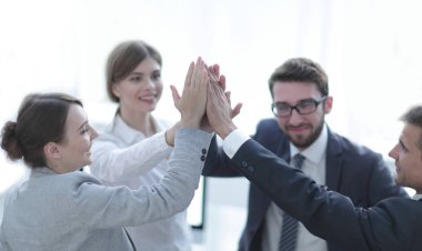 Başarılı bir iş ekibi ofiste birbirlerine beşlik çakıyor.