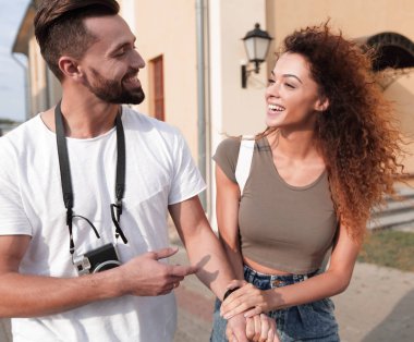 Bir çift şehrin sokaklarında yürüyor ve eğleniyor.