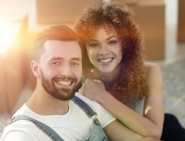 Genç bir çift yeni bir dairede yerde oturuyor.