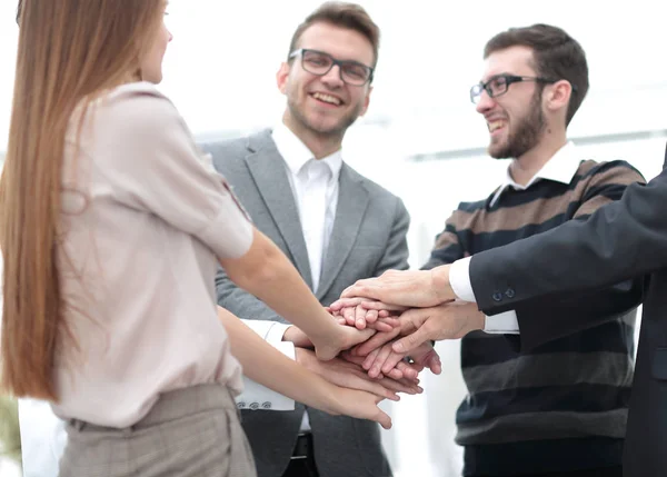 Equipo de negocios de pie uniendo sus manos — Foto de Stock