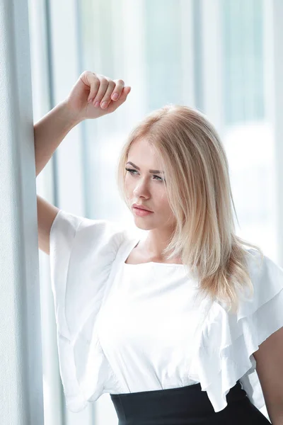 Moderne Geschäftsfrau sitzt am Fenster im Büro. — Stockfoto