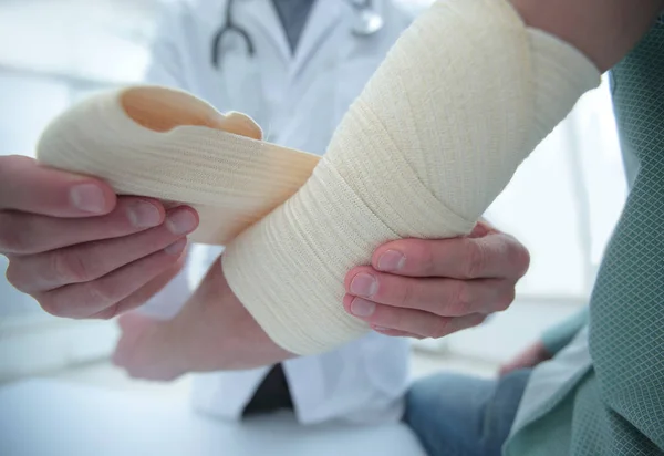 Ortopedie aplicând bandaj pe mâna pacienților în clinică — Fotografie, imagine de stoc
