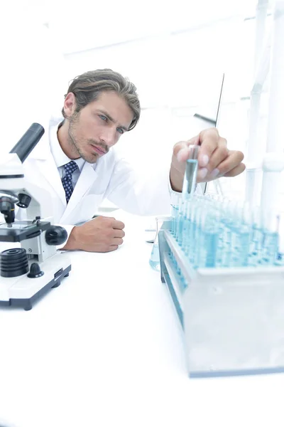 Químico mirando tubos de ensayo con líquidos azules Imagen De Stock