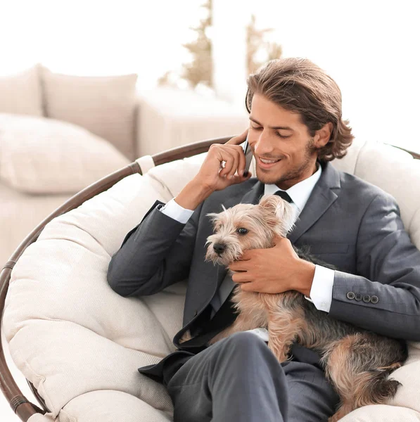 Zakenman is houden van zijn huisdier en spreken op een smartphone — Stockfoto