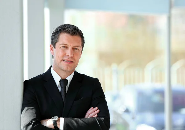 Hombre de negocios serio de pie cerca de la ventana en la oficina . —  Fotos de Stock