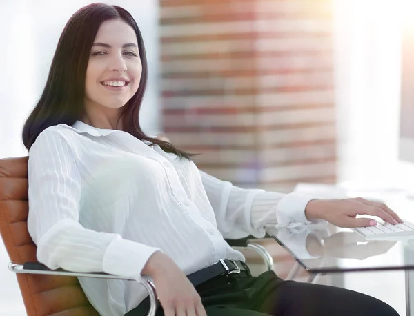 Успішна молода бізнес-леді сидить на робочому місці — стокове фото