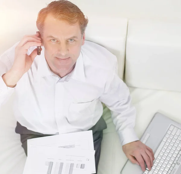 Geschäftsmann sitzt auf Stuhl und spricht auf einem Smartphone — Stockfoto