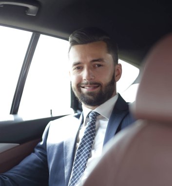 arabanın arka koltuğunda oturan yakışıklı sakallı işadamı