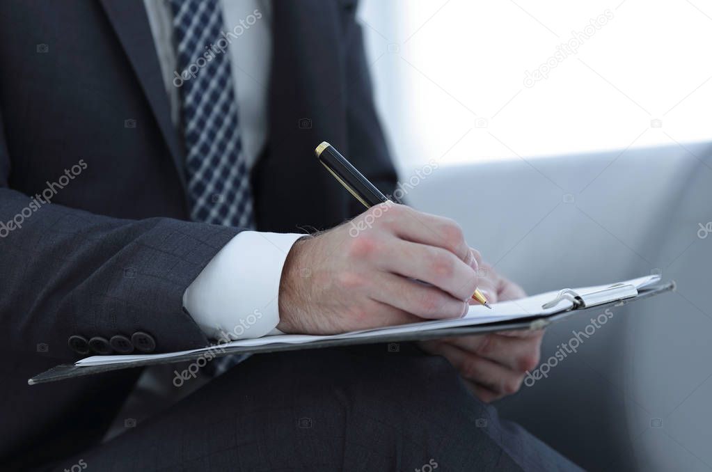 Businessman signs a contract. Holding pen in hand.