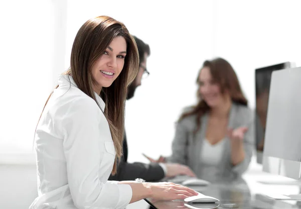 Lado view.smiling mujer de negocios sentado en el escritorio —  Fotos de Stock