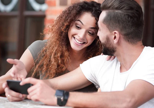 Feliz pareja amorosa usando un teléfono inteligente sentado en la terraza — Foto de Stock