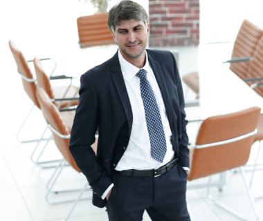 Bir boş toplantı odasında duran iş adamı