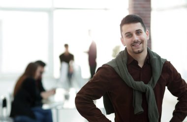 Kendine güvenen genç adam ofis arka planda.