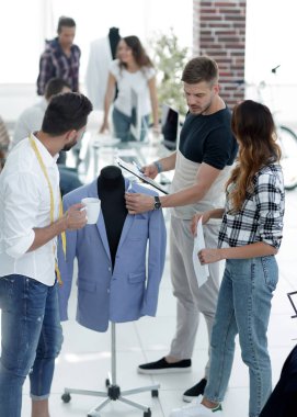 Bir grup tasarımcı erkek kıyafetlerini tartışıyor