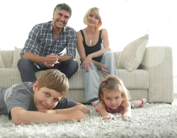 Retrato de familia feliz sentados juntos en la sala de estar —  Fotos de Stock