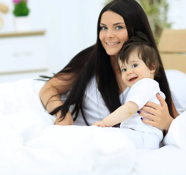 Güzel bir anne ile bebeği yatak odasında portresi — Stok fotoğraf