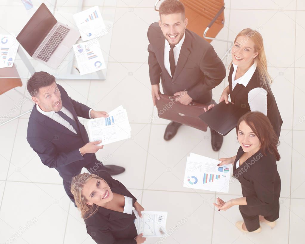 view from the top.business team discussing marketing charts,standing in the office.