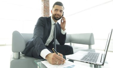 İşadamı Smartphone'da finansal belgeler hakkında konuşmak