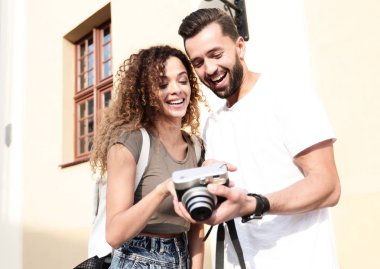 Fotoğraflara bakarak yürüyen genç arkadaşların portresi