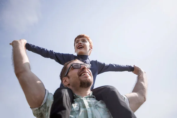 Happy father holds his son on his shoulders — Stock Photo, Image