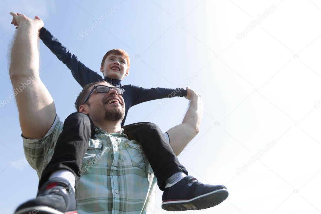 happy father holds his son on his shoulders